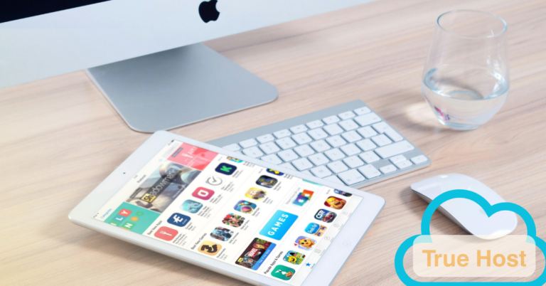 a desktop and glass of water and a iPad with apps menu open and the TH logo